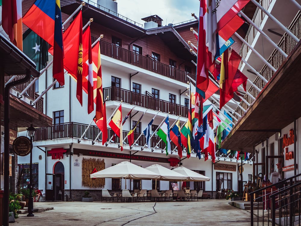 Free A lively urban street adorned with colorful international flags and modern architecture. Stock Photo